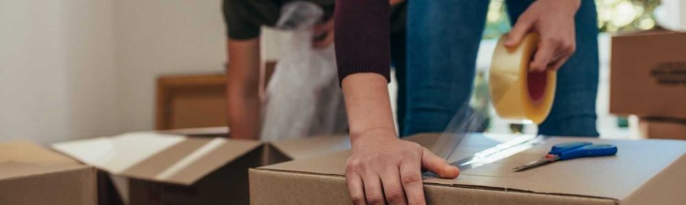 to mennesker, der er ved at pakke flyttekasser